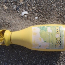 Plastic Pollution Foreign Mustard Bottle polluting beach