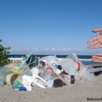 Plastic pollution, fishing line, glass bottle debris on beach